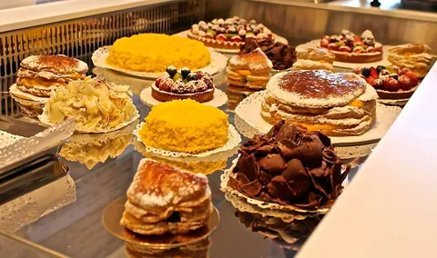 Vetrina con torte mimosa, millefoglie e torte al cioccolato